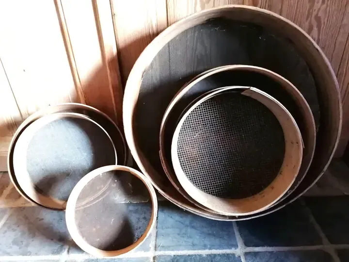 Oude, verweerde zeven, brocante bij Guirlande Bellem