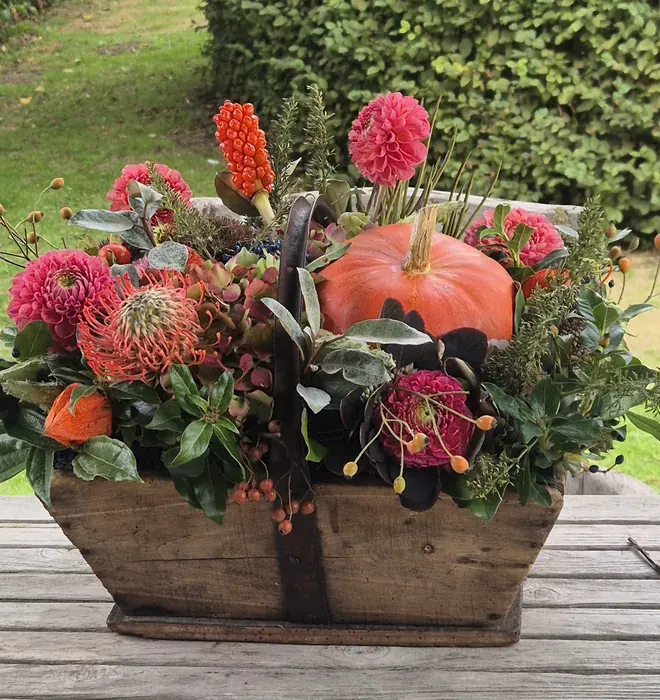 Rijkelijk gevulde oogstmanden in grijstinten, met dahlia's en met zonnebloemen, en de oude Franse manden in de schuur