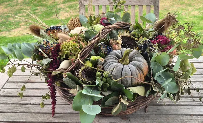 Rijkelijk gevulde oogstmanden in grijstinten, met dahlia's en met zonnebloemen, en de oude Franse manden in de schuur