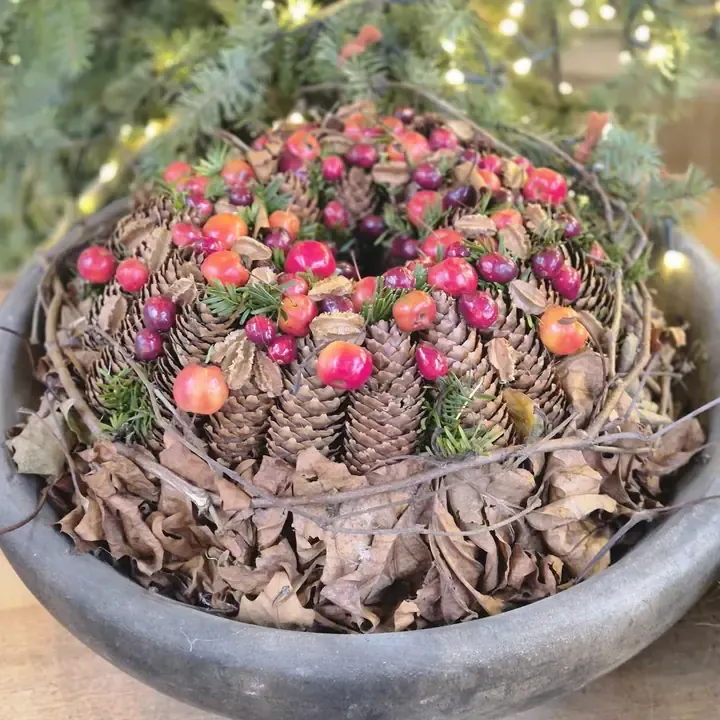 Kersttafelstuk met dennenappels en bessen